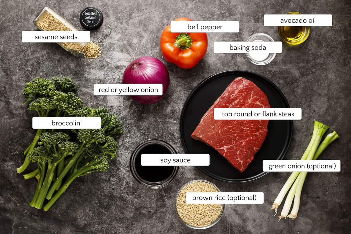 Ingredients for beef and broccolini stir fry include beef sirloin, red bell pepper, red onion, broccolini, soy sauce, baking soda, high-heat cooking oil, toasted sesame seeds, scallions, and brown rice.