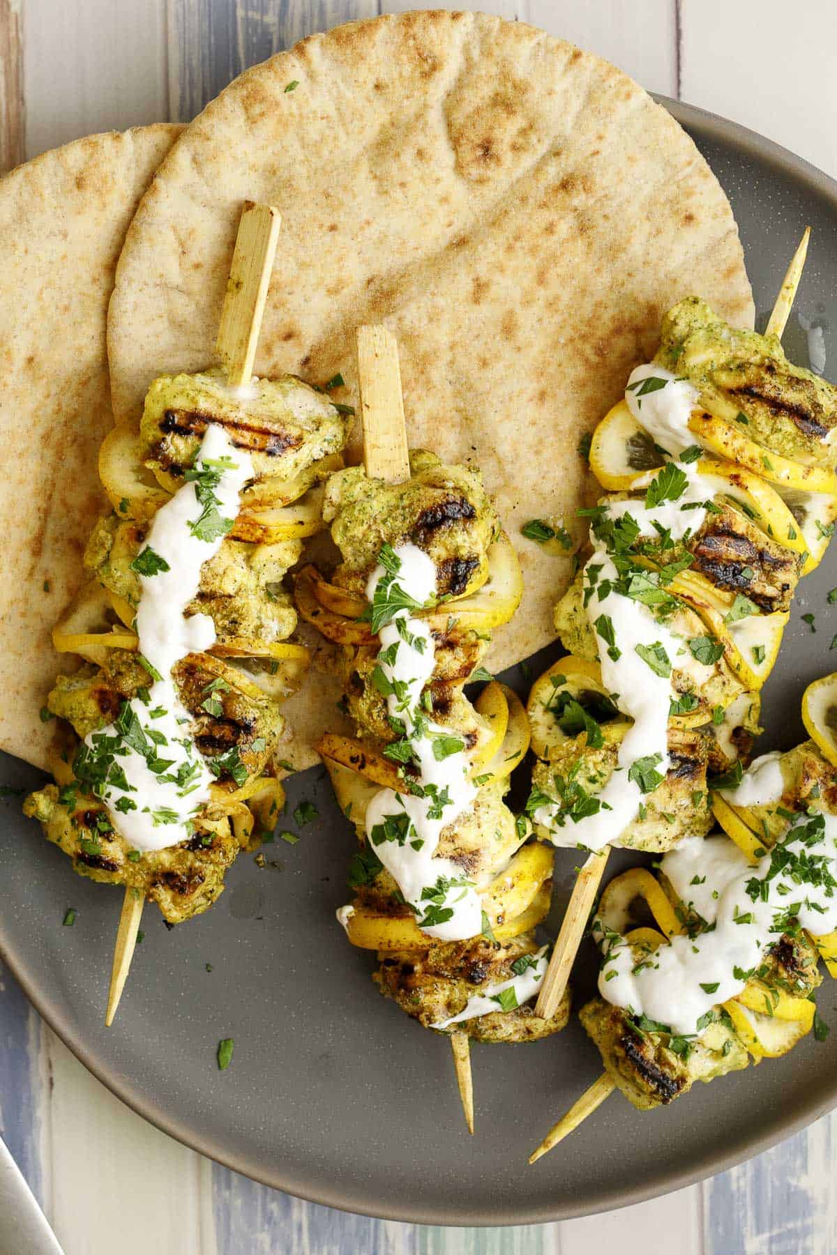 grilled halibut kebabs on a platter with pita bread
