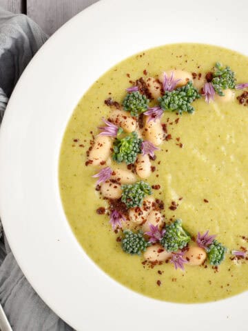 broccolini soup in a bowl with a spoon and a napkin.