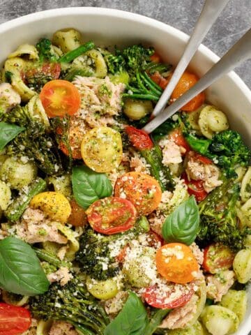 Broccolini pasta with pesto and tuna in a bowl with serving utensils