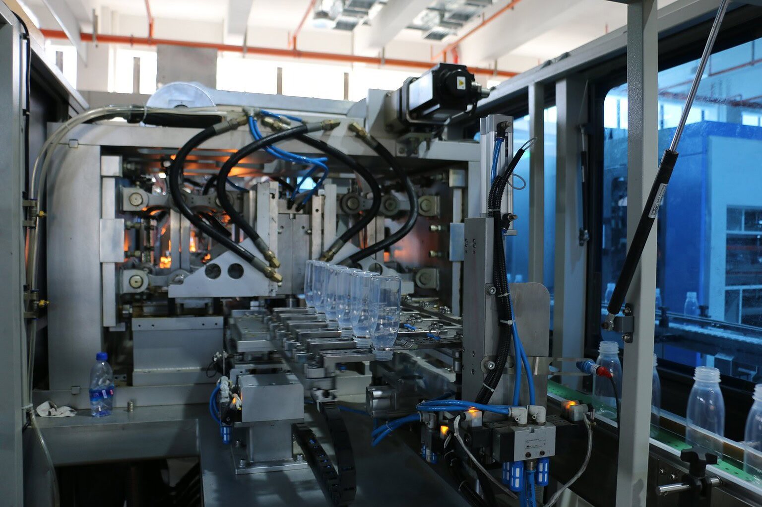 Automated glass bottle production machinery in a factory setting.