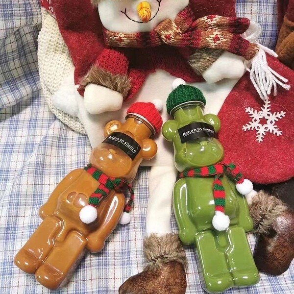 Cute bear-shaped juice bottles with holiday accessories for festive drinks.