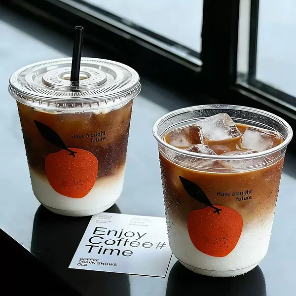 U-shaped plastic cups filled with coffee are placed on the bar counter. PET cups are suitable for juice shops, café shops, soft drink shops, and bubble tea shops.