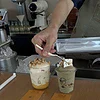 U-shaped plastic cups filled with coffee are placed on the bar counter. PET cups are suitable for juice shops, coffee shops, soft drink shops, and bubble tea shops.