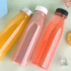 Colorful plastic bottles for beverages on a pastel background.