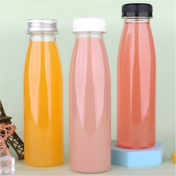 Set of three colorful plastic bottles with different caps on pastel background.