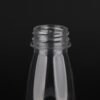 Clear plastic bottle for beverages with screw cap opening.