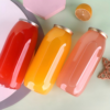 Colorful glass jars with metal lids on pastel background.