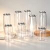 Clear empty PET soda cans with easy open lids displayed on a table.