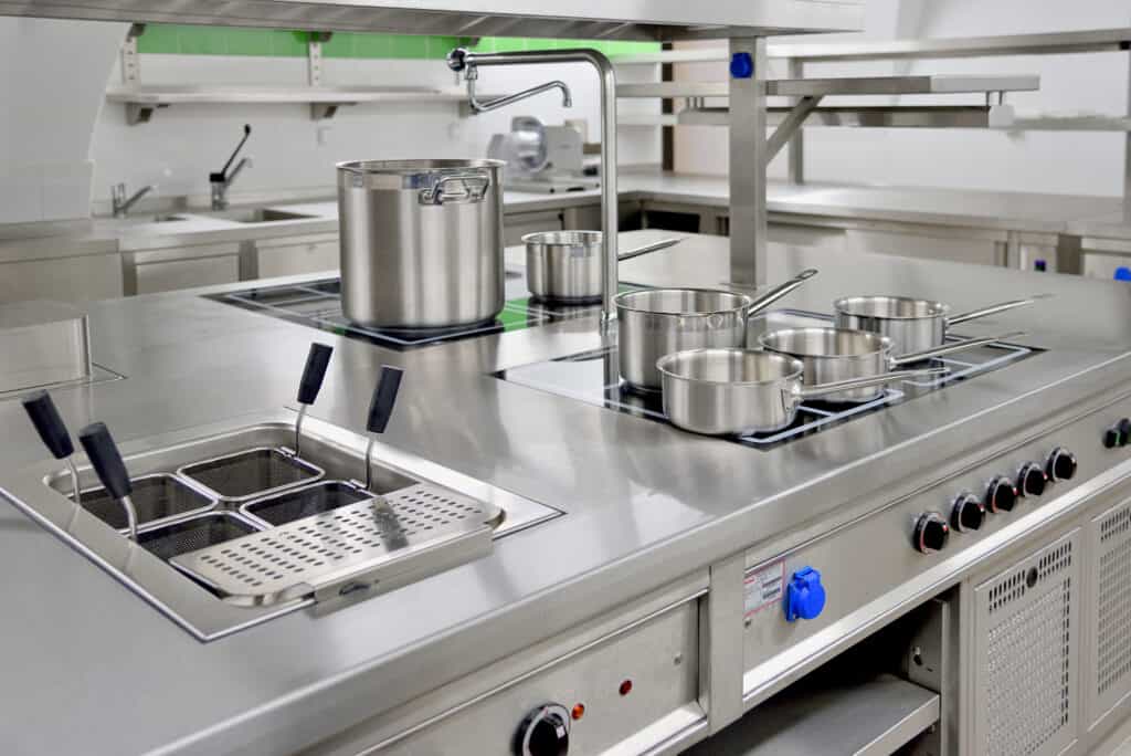 Stainless steel pots built on the stove in the restaurant kitchen