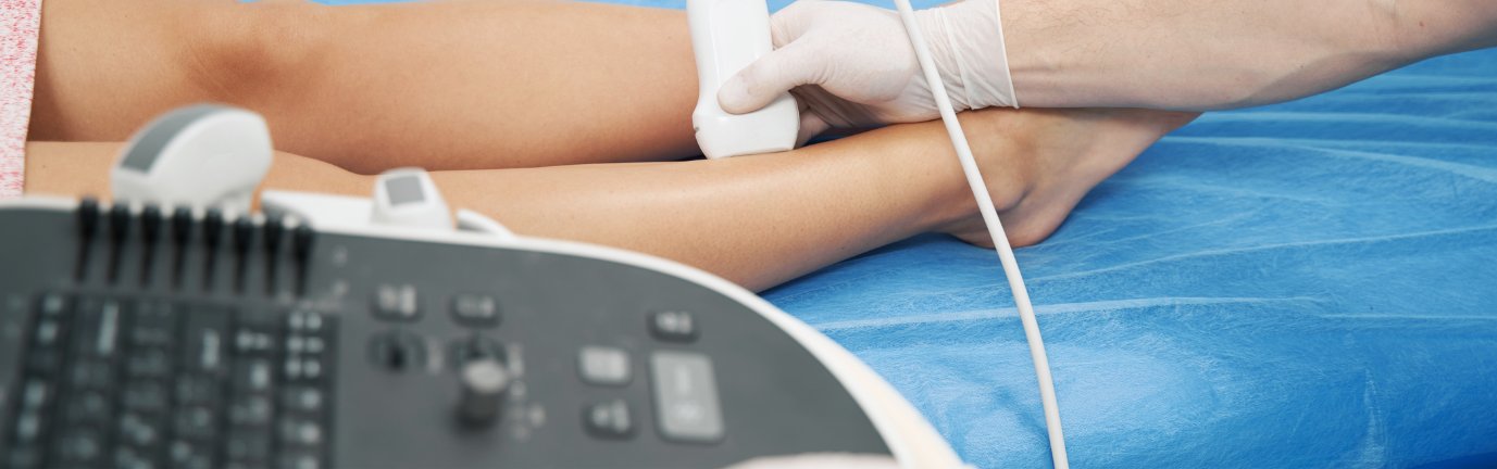 Ecodoppler alla caviglia con sonda ecografica e paziente sdraiato