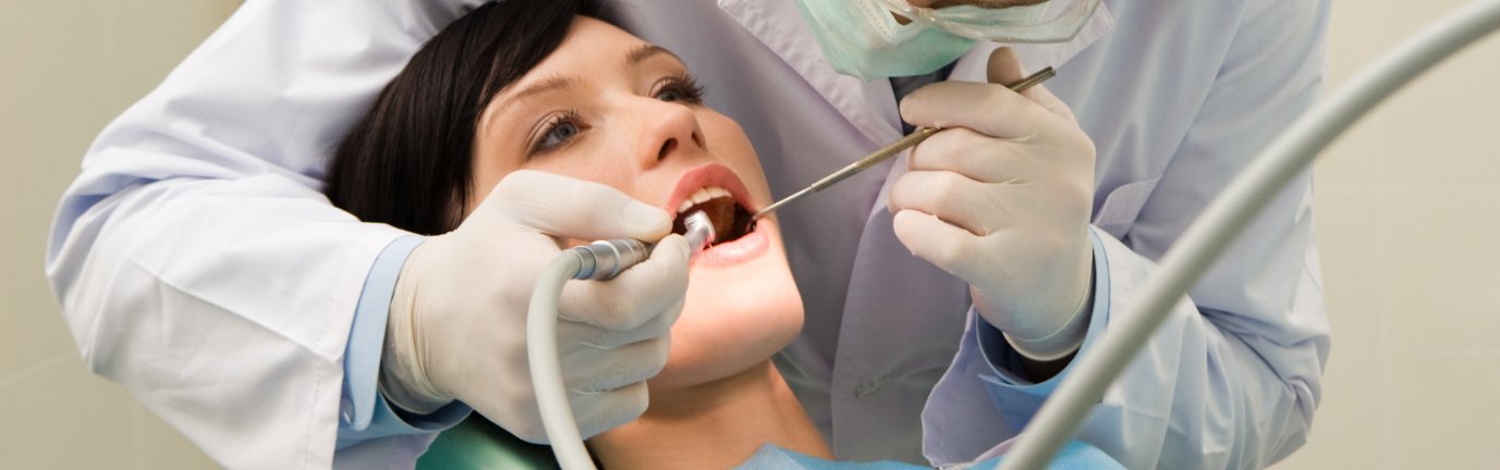 Dentista esegue igiene orale professionale su paziente