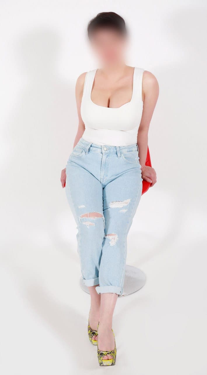 Persona sentada con jeans rotos y camiseta blanca