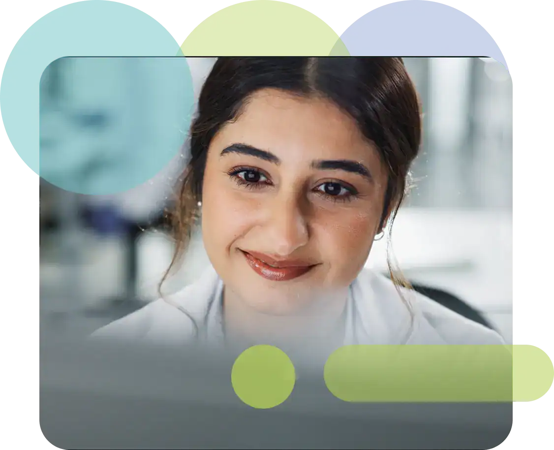 Close-up of a smiling female healthcare professional in a clinical setting.