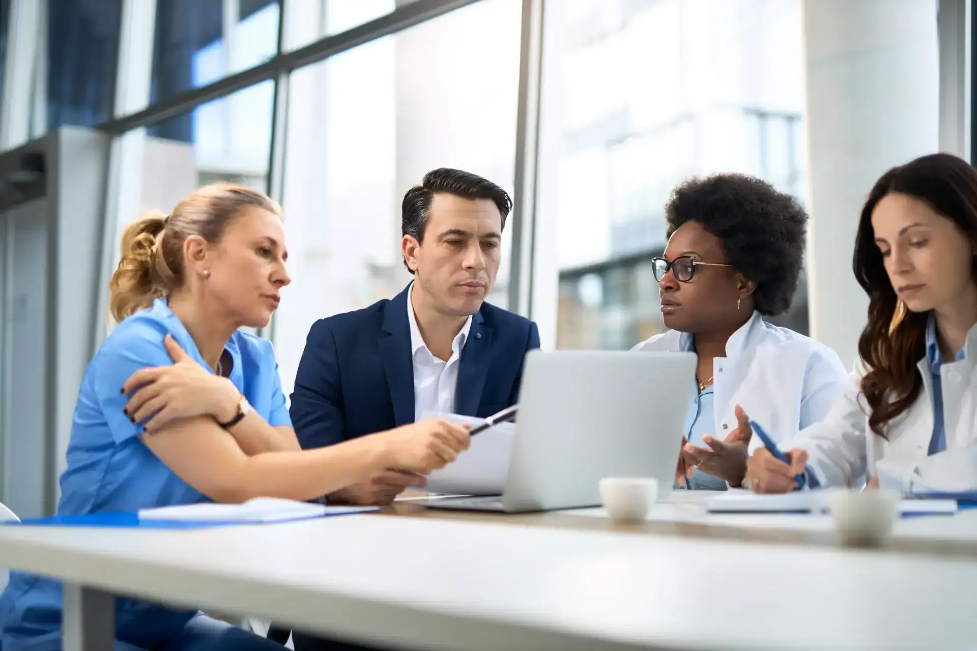 Medical professionals discussing patient care in a modern office setting.