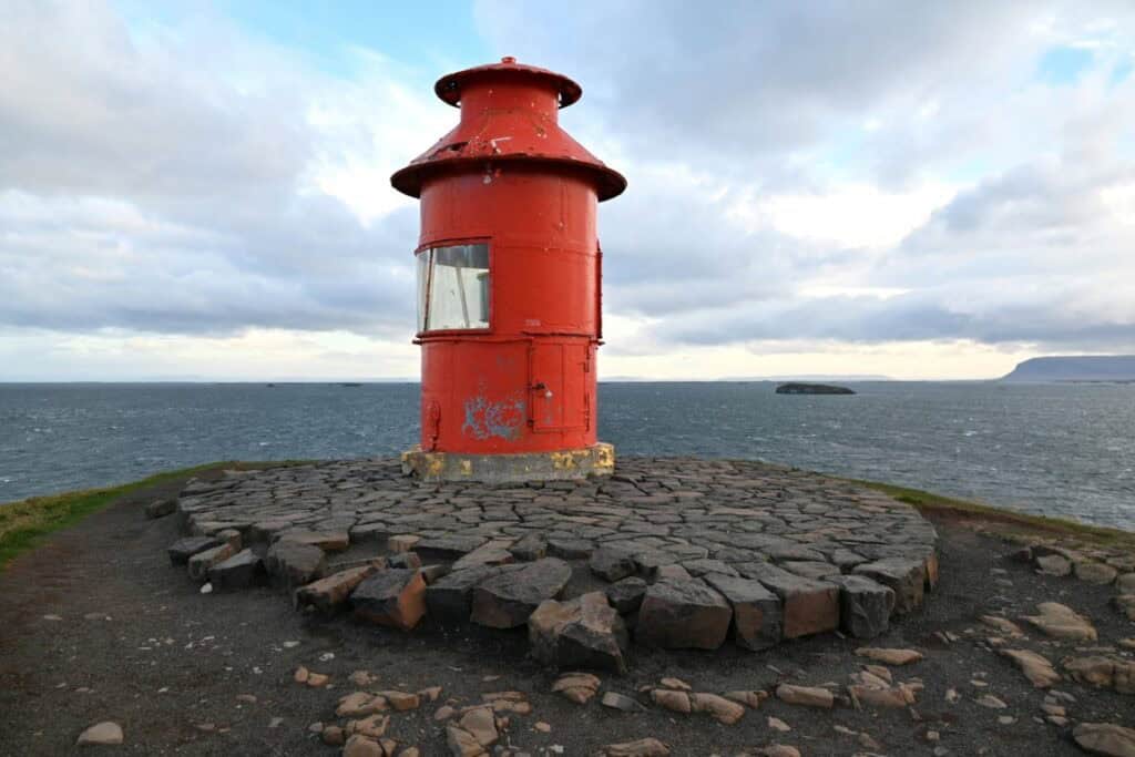Lighthouse on the rugged coast of Snæfellsnes Peninsula, Iceland, with ocean views and dramatic skie.
