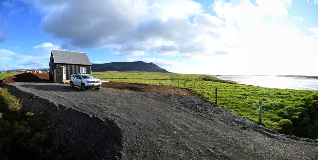 Scenic view of Snæfellsnes Peninsula with a small house and car near the coast.