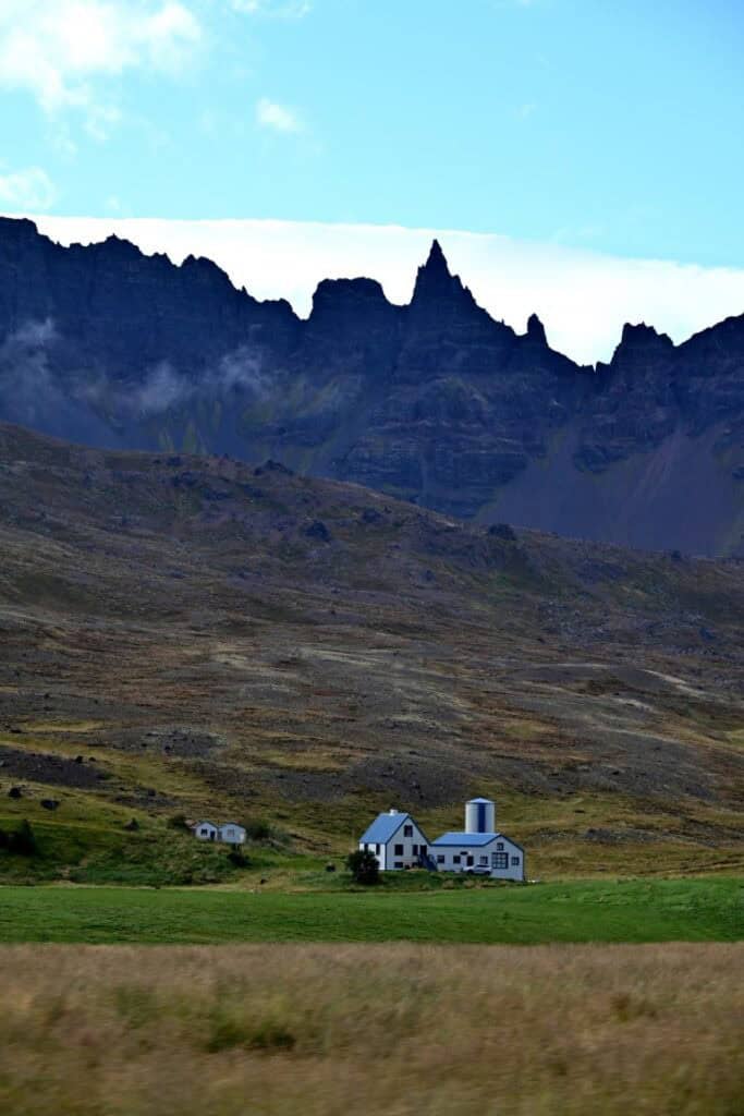 Scenic view of Icelandic landscape with mountains and a small white house near Hvitserkur.
