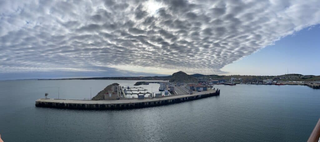 Îles-de-la-Madeleine harbor with boats and dramatic cloudscape in May.