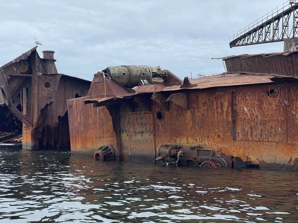Wreck of the Duke of Connaught shipwreck on the shoreline, showcasing rusted metal and remnants of t.