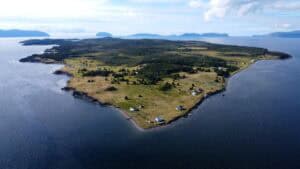 Aerial view of Woods Island with lush greenery and scattered cabins on the shoreline.