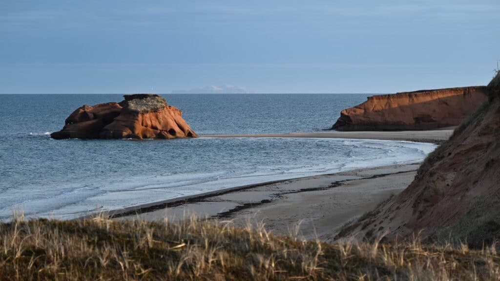 Beautiful Îles-de-la-Madeleine coastline in May with sandy beaches and rugged cliffs.
