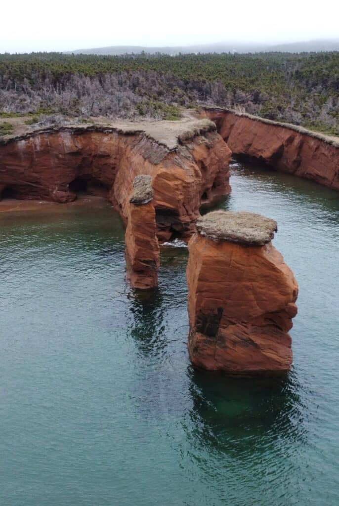 Unique red sandstone formations along the river in Fatima, Quebec.