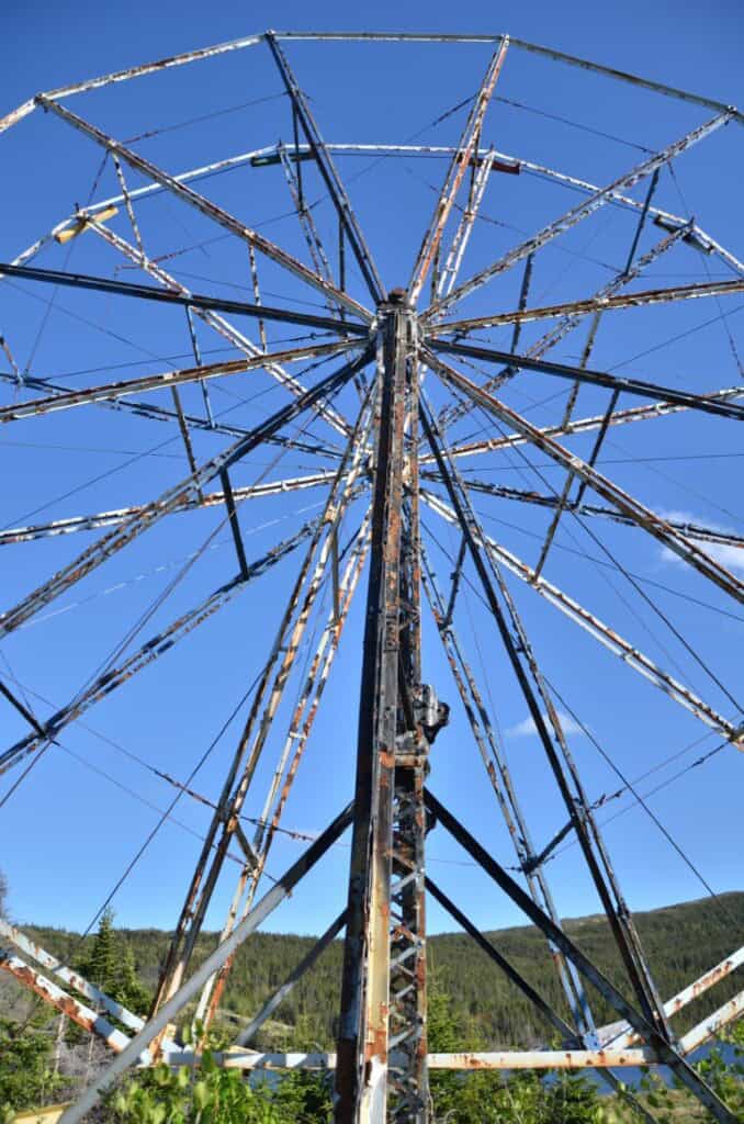 Rusty Ferris wheel with weathered metal against bright blue sky at The Trinity Train Loop.