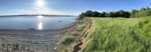 Scenic view of Cocagne Island shoreline with grassy banks and calm water.