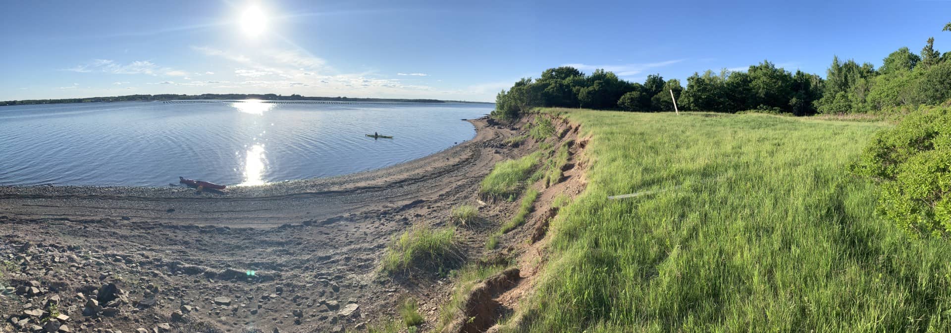 Scenic view of Cocagne Island shoreline with grassy banks and calm water.