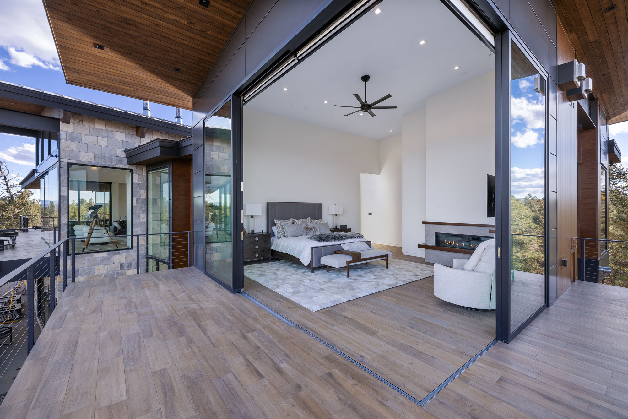 Spacious bedroom featuring floor-to-ceiling glass walls, modern furnishings, and natural light, show.