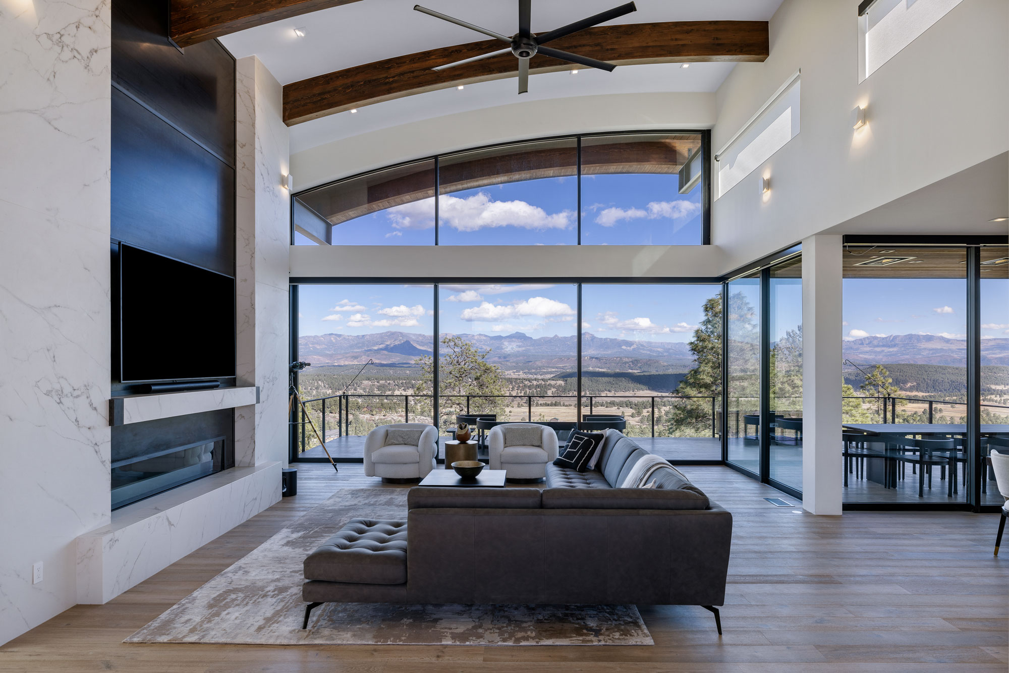 Modern living room featuring large floor-to-ceiling windows overlooking scenic mountain landscape.