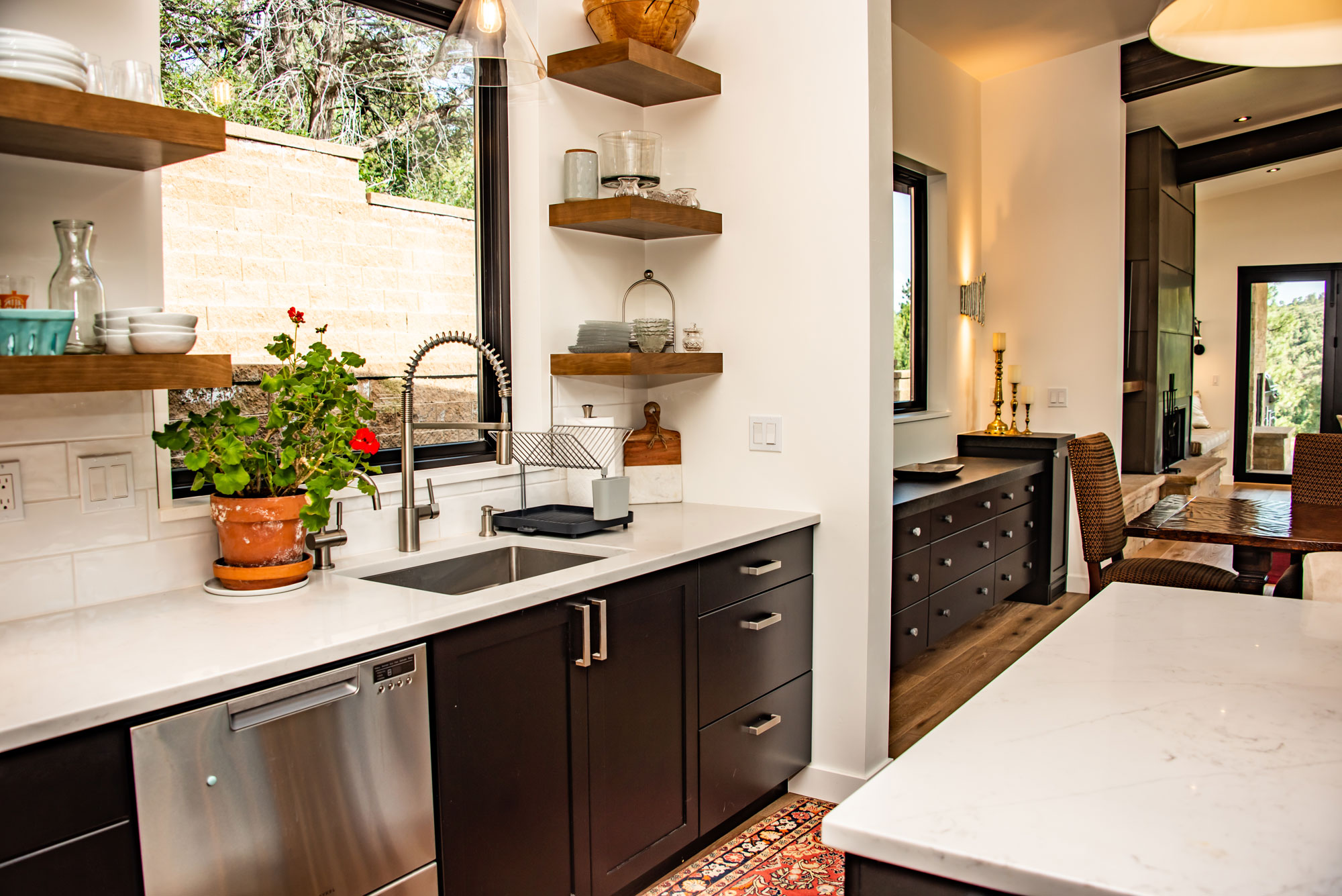Contemporary kitchen with open shelves, black cabinetry, and marble countertops.