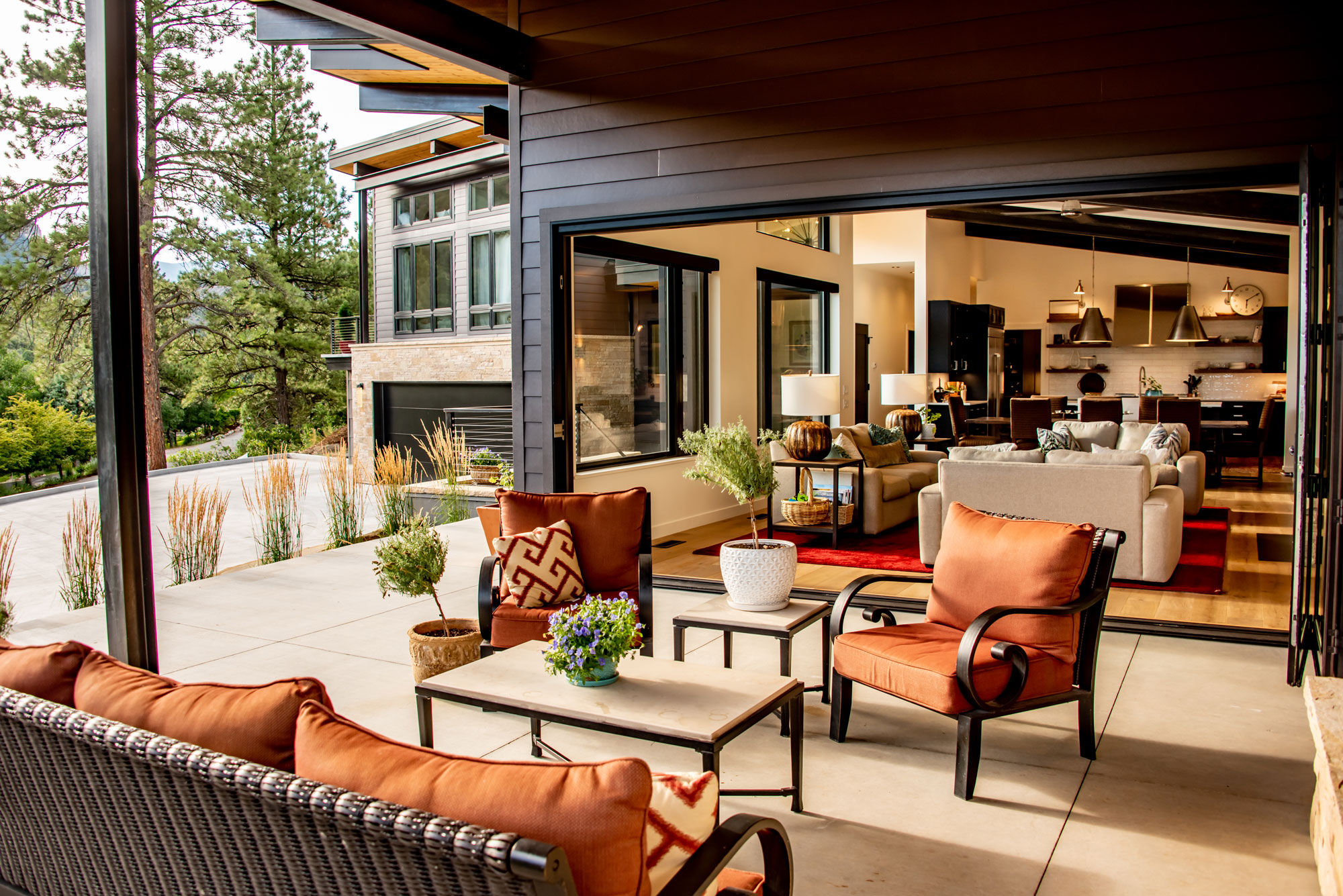 Contemporary outdoor patio with seating and view of lush greenery.