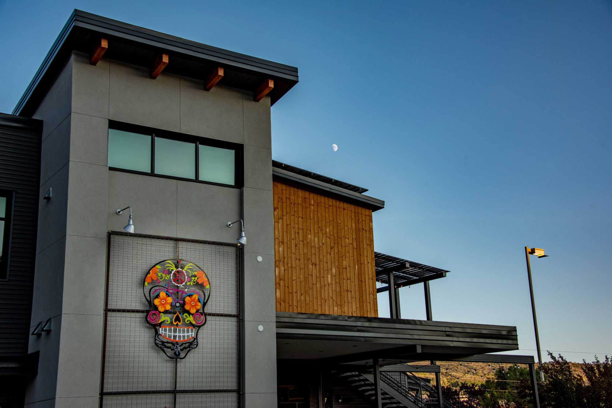 Contemporary building with colorful skull art for Zia Taqueria restaurant.