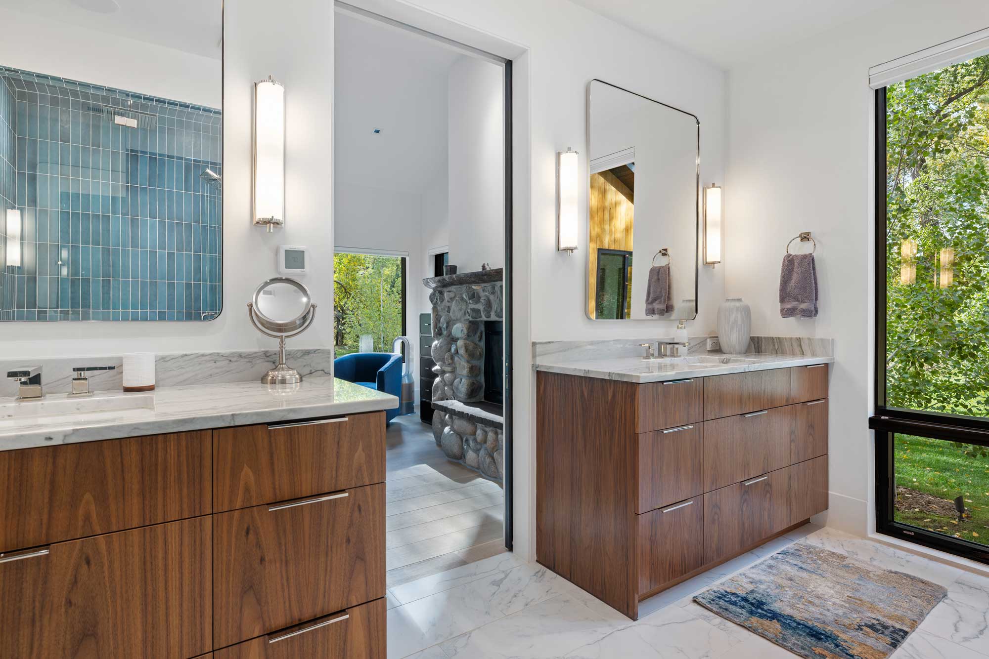 Elegant bathroom featuring wooden vanities and large windows for bright, airy ambiance.