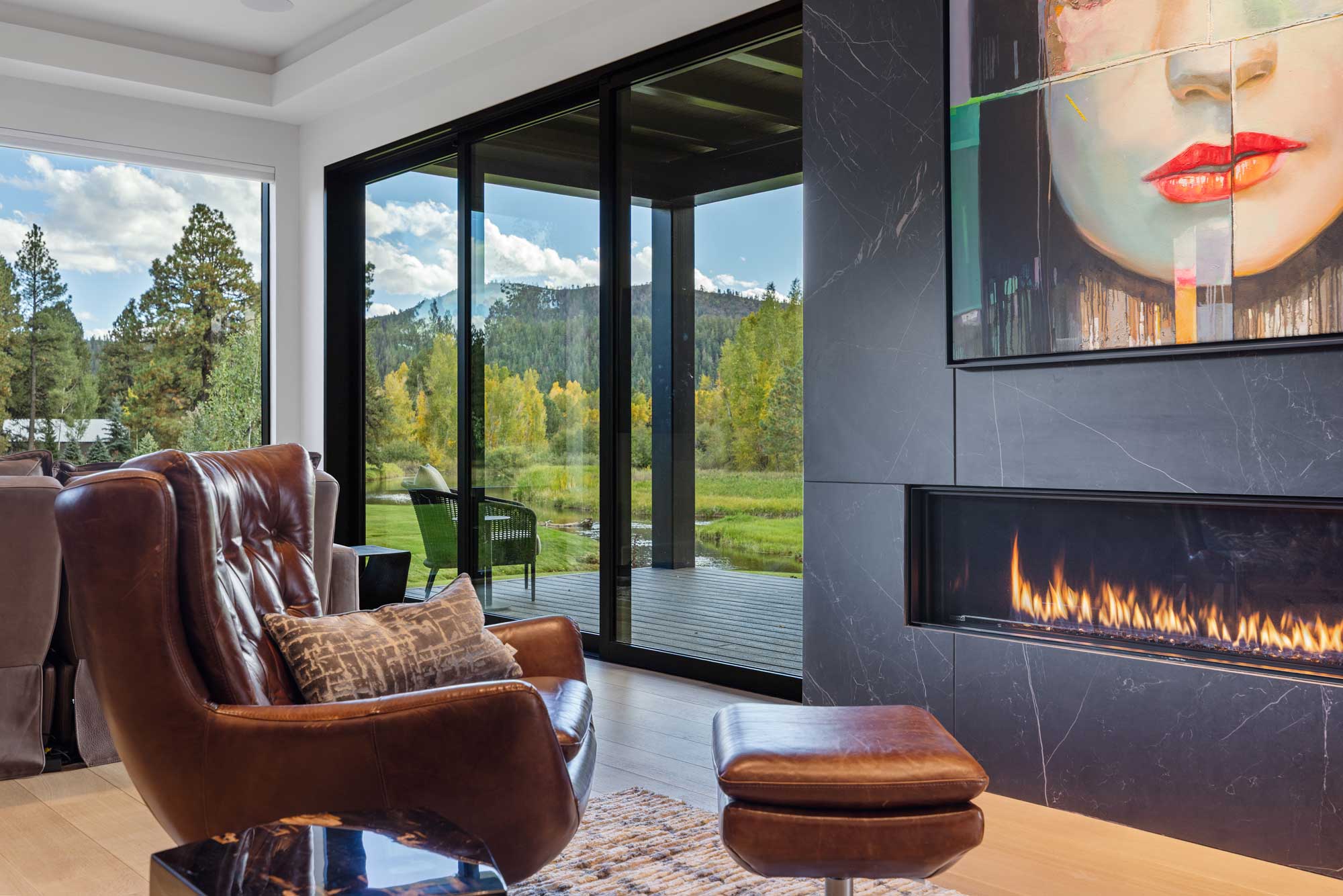Modern living room with large windows and scenic outdoor views.