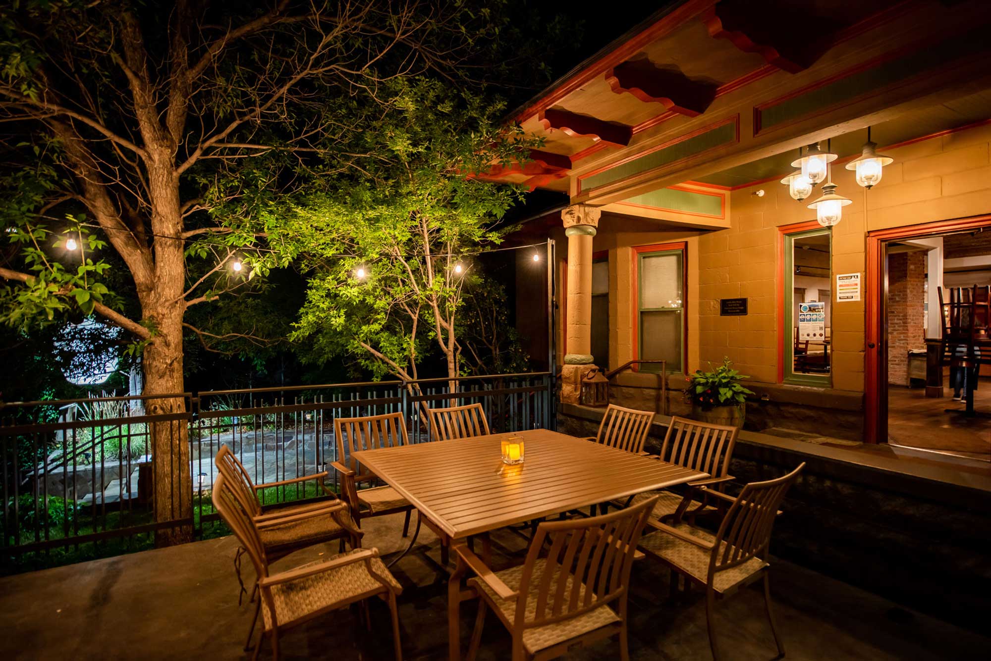 Alley House Grille outdoor patio at night with dining table and chairs.
