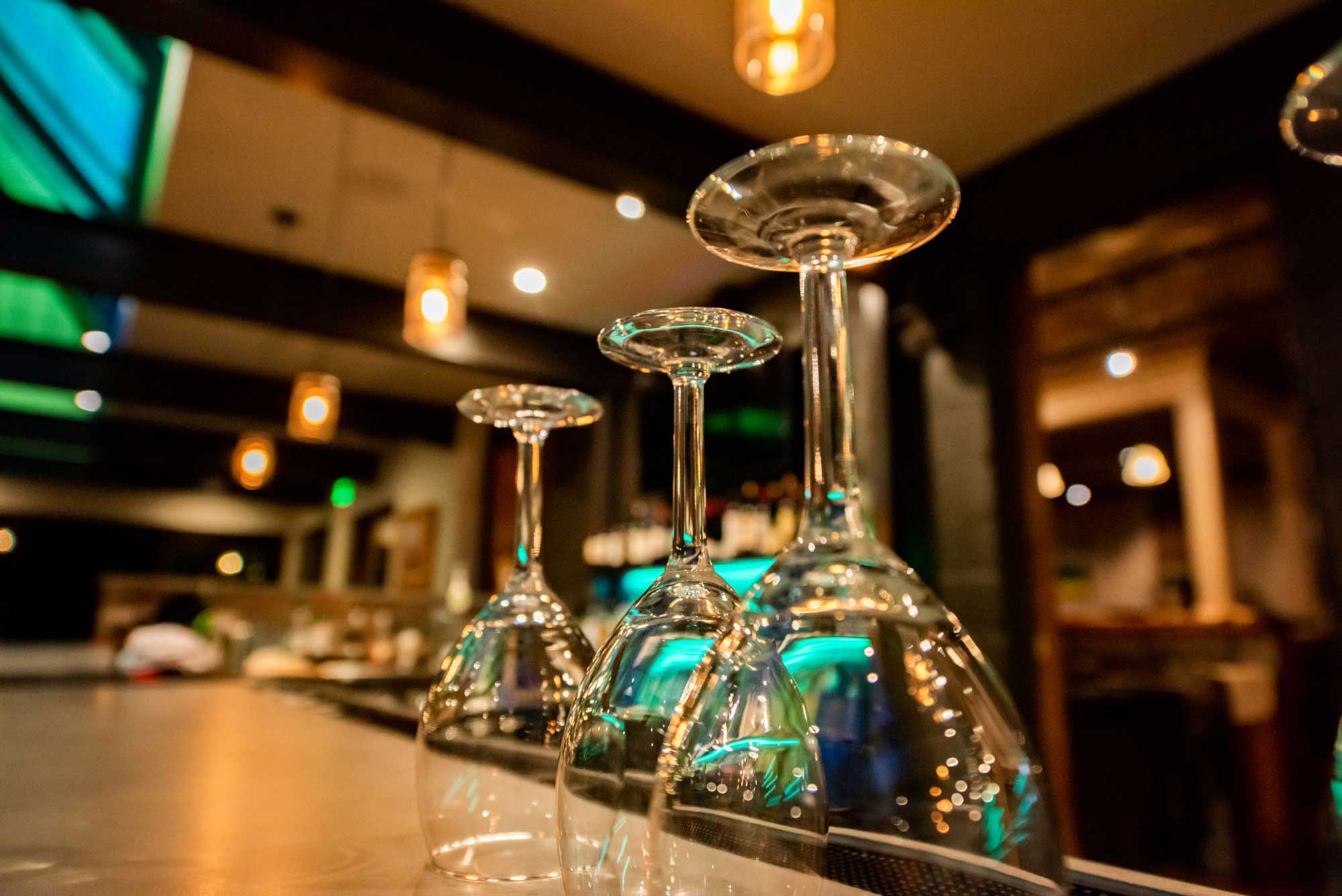 Elegant glassware on a bar counter at Alley House Grille restaurant.