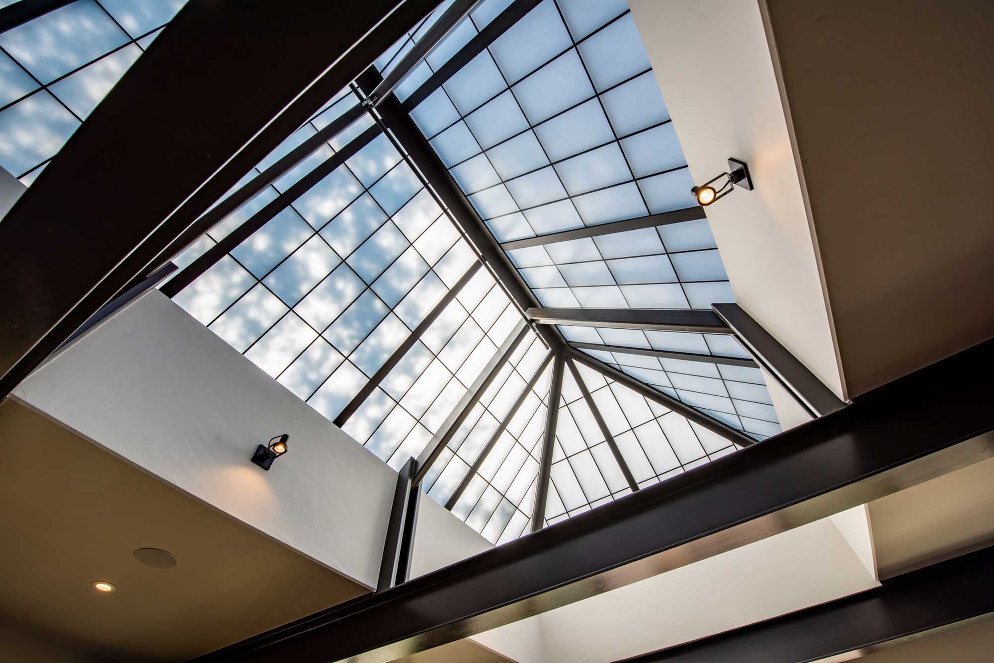 Glass skylight with sleek metal framing at Alley House Grille. Bright, airy interior with natural li.