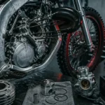 Moto 125 2 temps démontée en atelier, cylindre et piston visibles