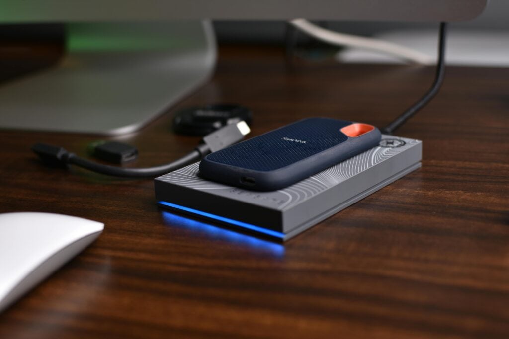 External SSD next to a laptop for hybrid local and cloud backup