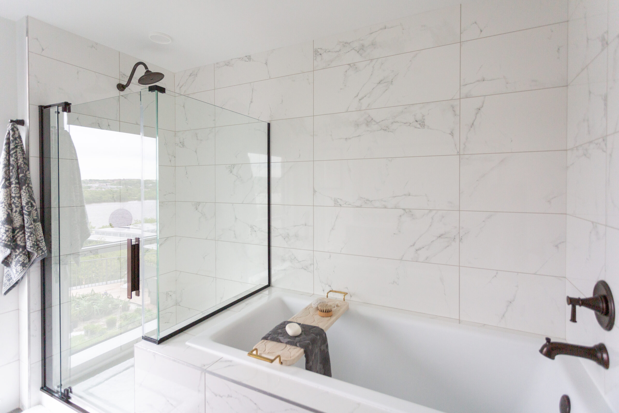 modern apartment bathroom with separate shower and bath tub with marble tiles on the wall