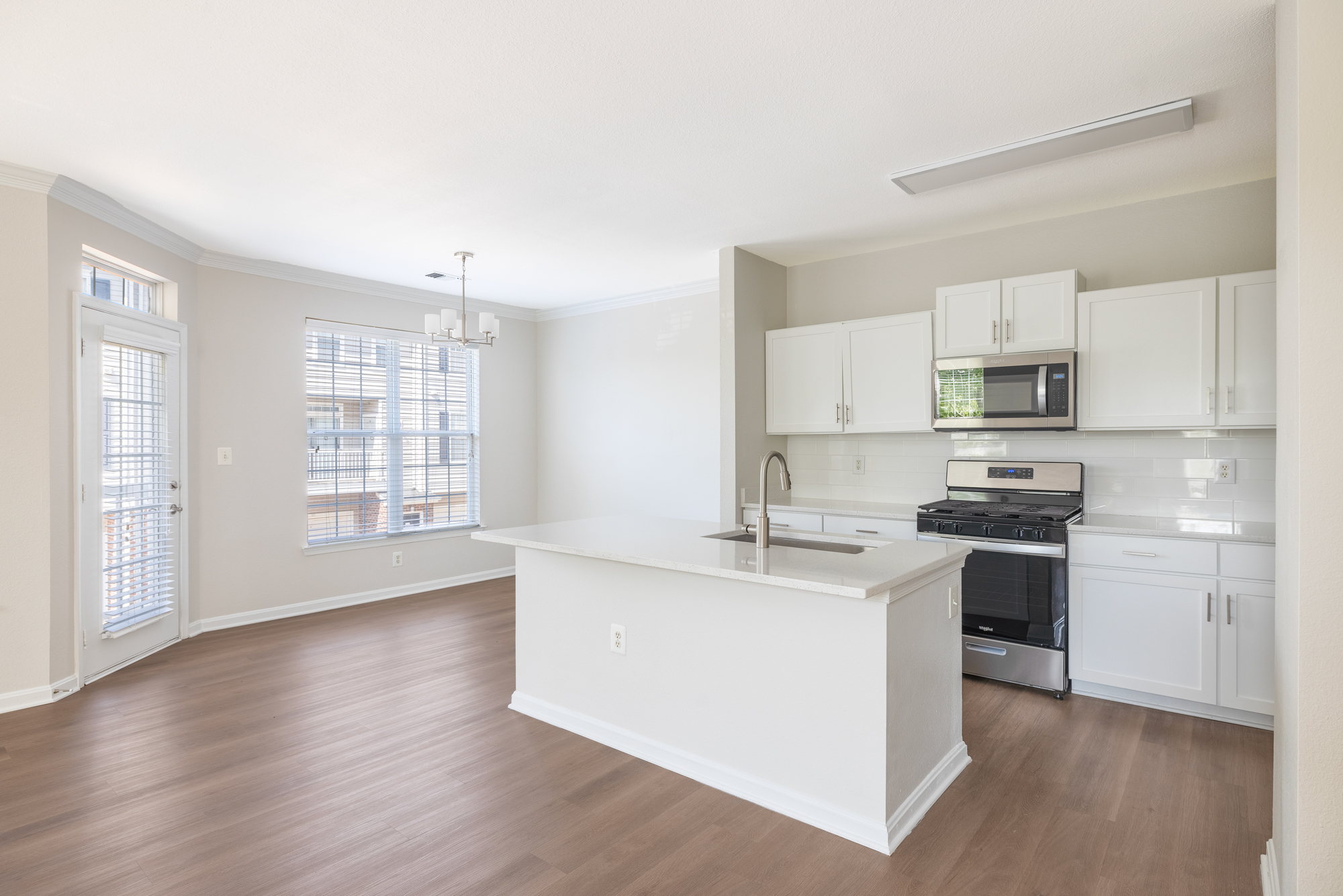 Inside of townhome at Cameron Court with bright light from expansive windows and kitchen with quartz countertops.