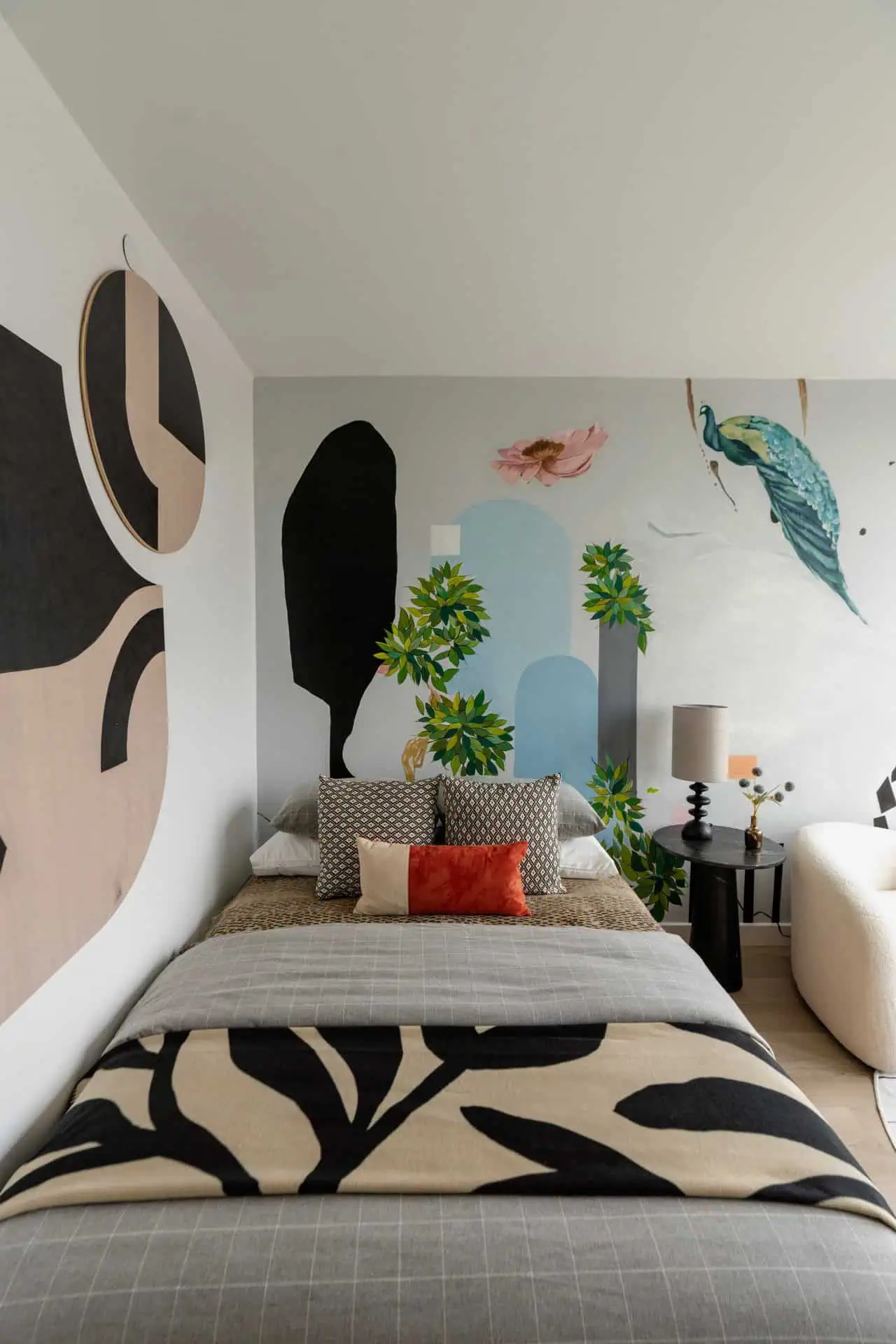 A bedroom with a large bed and a wall mural.