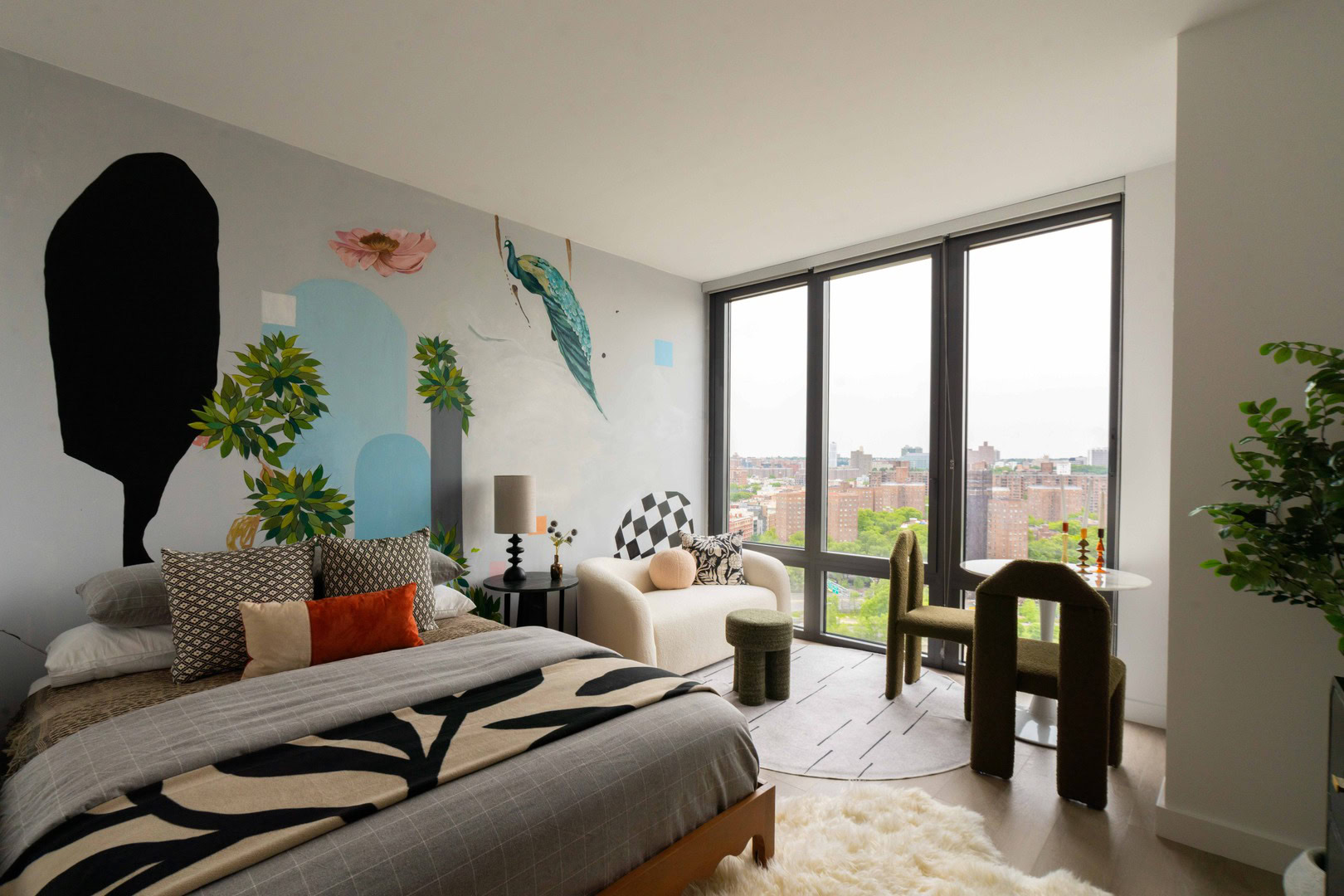 A bedroom with a large bed and a wall mural.