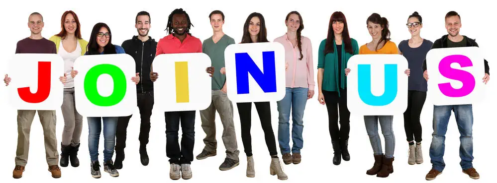 People holding a sign that reads "join us"