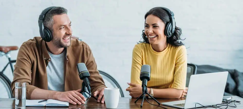 Man interviewing a woman while recording a podcast