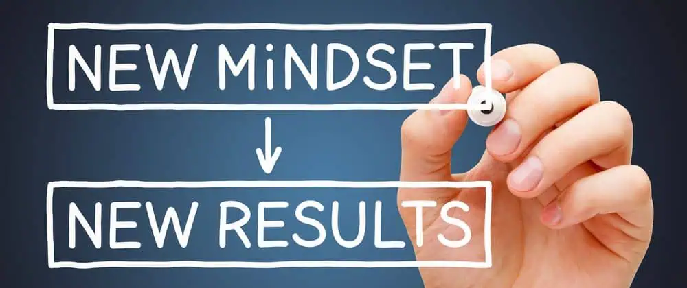 Someone writing "new mindset, new results" on a glass screen