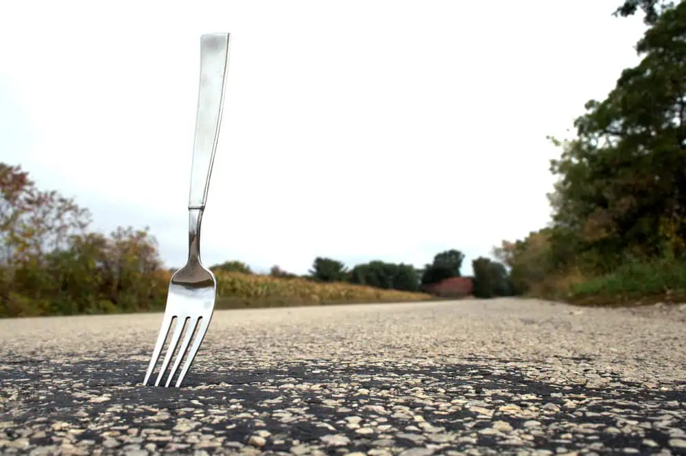 A fork in the road - literally a piece of cutlery sticking out of the tarmac